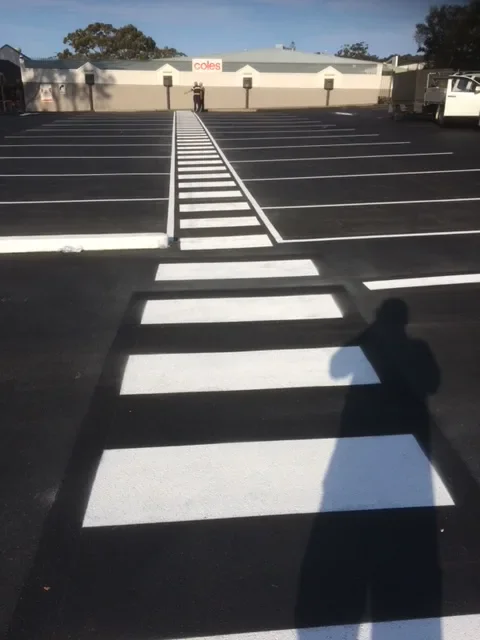Freshly marked pedestrian crossing and parking bays at a shopping centre car park
