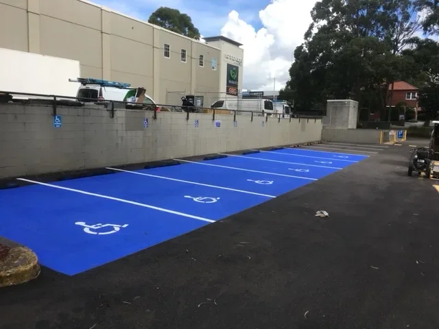 Blue disabled parking bays with wheelchair symbols at a retail car park