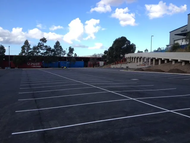 Newly marked white parking bay lines on a large commercial asphalt car park