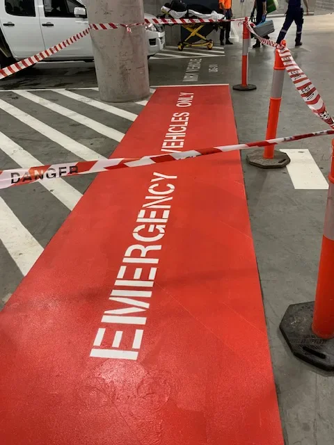 Red emergency vehicles only floor marking with white stencil text