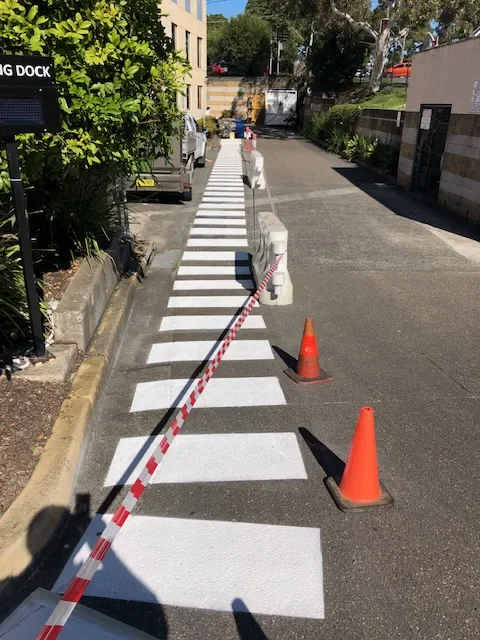 Fresh white zebra crossing stripes at a commercial loading dock