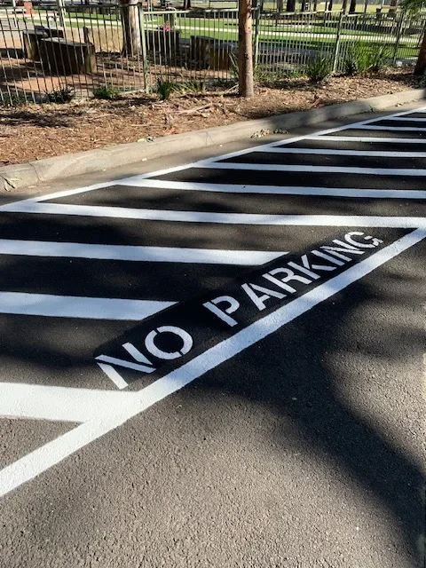 White no parking stencil with diagonal hatching on asphalt