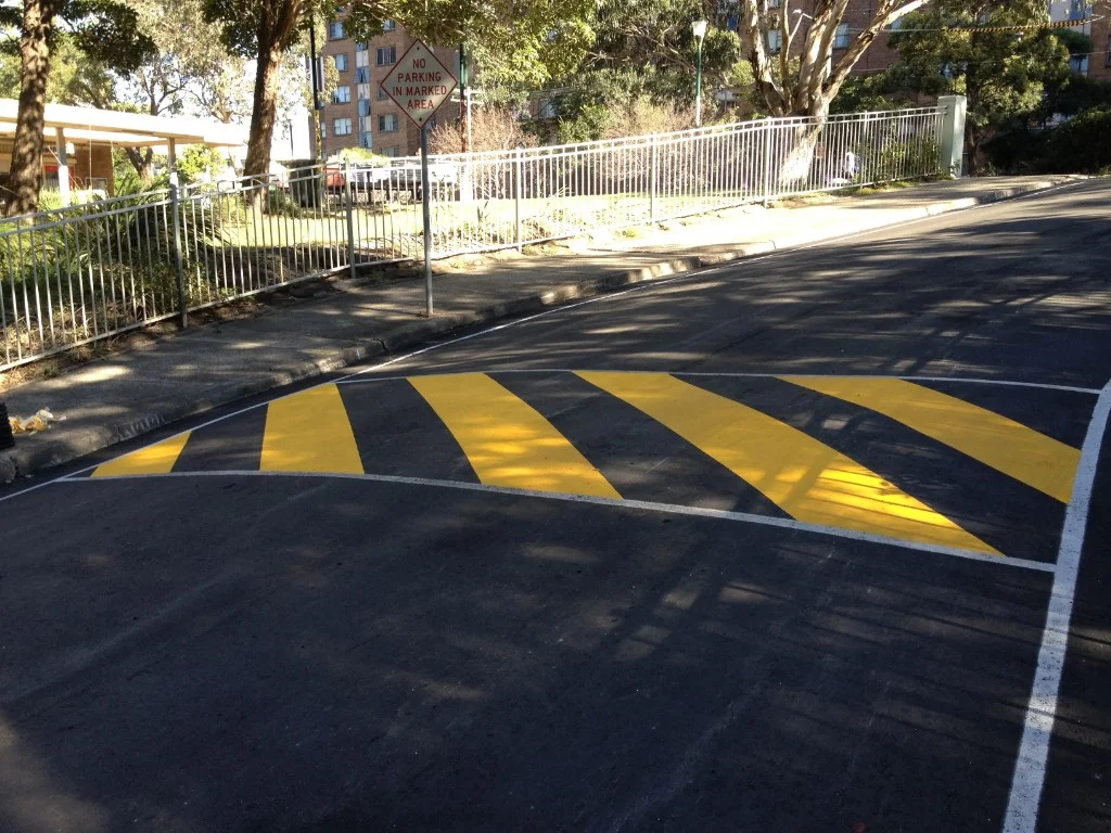 Yellow and black chevron markings on a speed hump on a suburban road