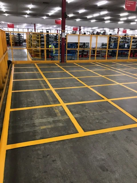 Yellow grid line markings defining storage bays on a warehouse floor