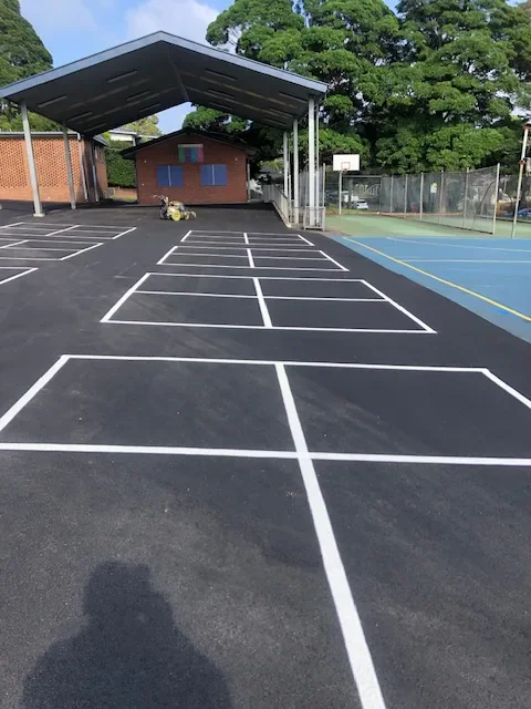 Rows of white four-square handball courts on a school playground