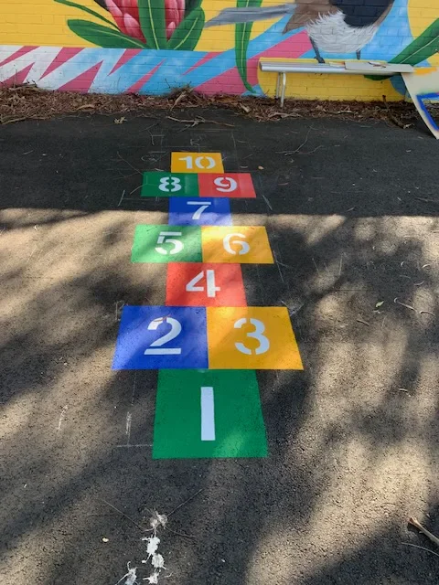 Colourful numbered circles with maths symbols on a school playground