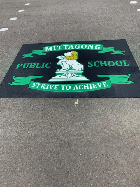 Mittagong Public School emblem and motto stencilled on a playground surface